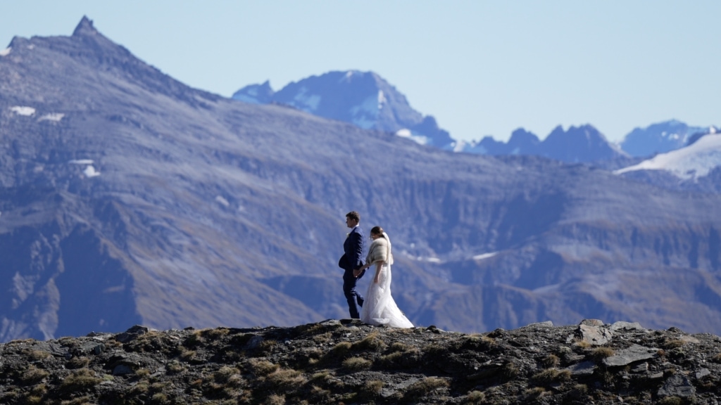 Married couple walk along remote mountaintop in New Zealand